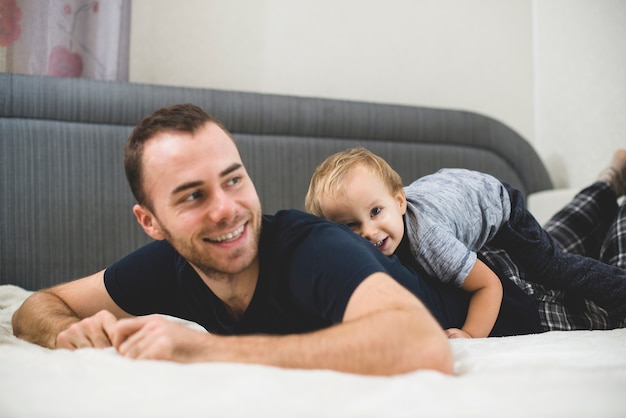 Free photo kid lying on his father's back