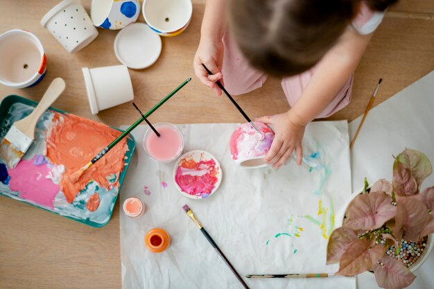 Kid painting plant pot DIY hobby