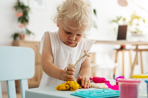 Kid playing indoors with playdough