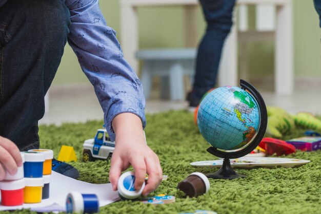 Kid playing paints on floor