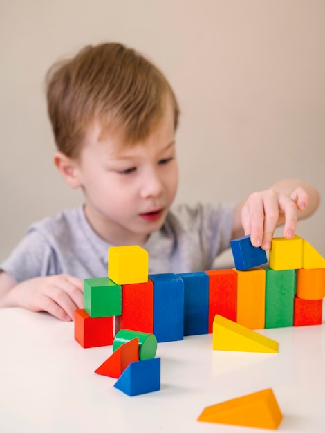 Foto gratuita bambino che gioca con il gioco di forme colorate