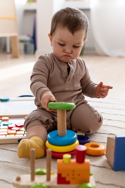 Kid playing with colorful toys full shot