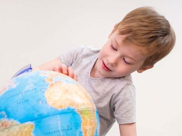 Free photo kid playing with earth globe