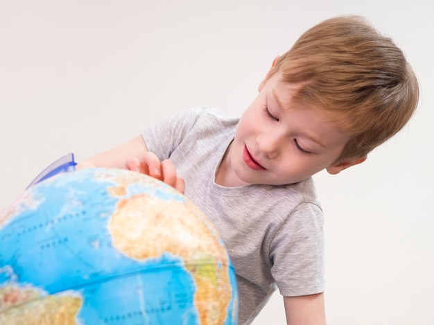 Bambino che gioca con il globo terrestre