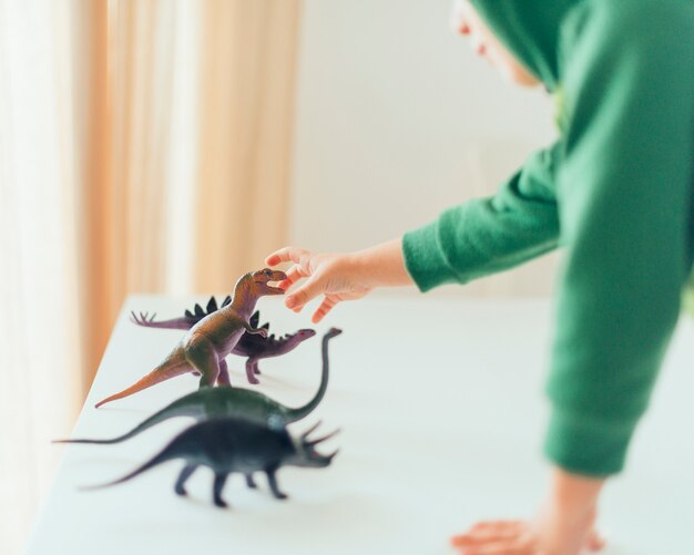 Kid playing with toy dinosaurs