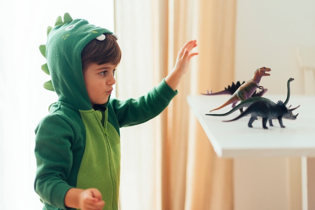 kid playing with toy dinosaurs