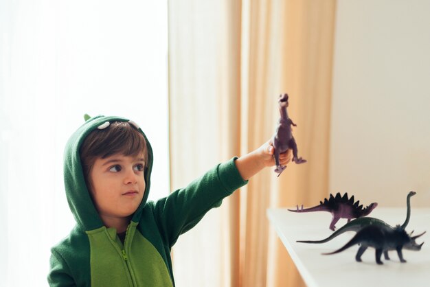 Kid playing with toy dinosaurs