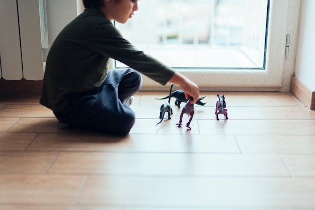 Kid playing with toy dinosaurs