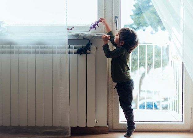 Kid playing with toy dinosaurs