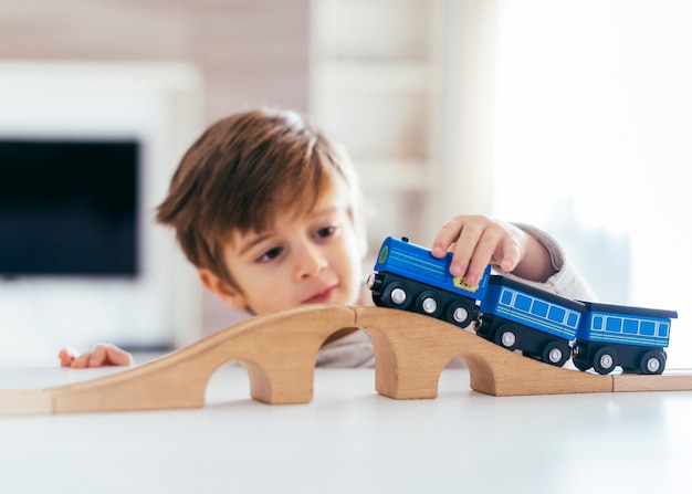Малыш играет с игрушечным поездом