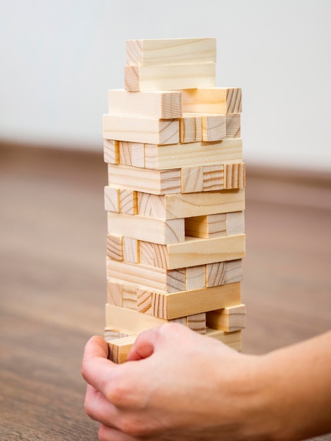 Foto gratuita bambino che gioca con il gioco della torre di legno