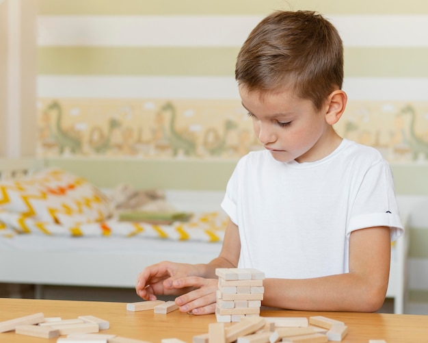 Kid playing a wooden tower game alone