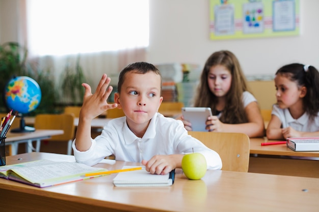 Kid posing at desk in classroom