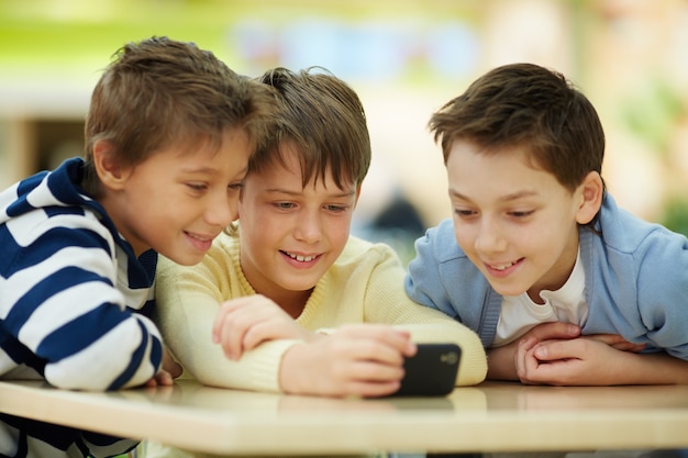 Foto gratuita bambino che mostra il suo nuovo cellulare