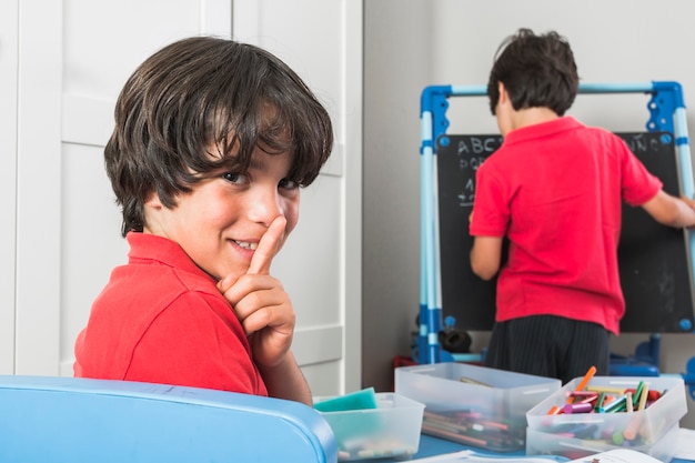 Free photo kid showing silence gesture