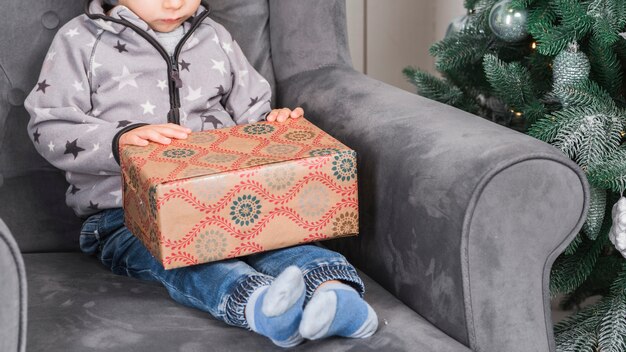 Kid sitting on couch with present box