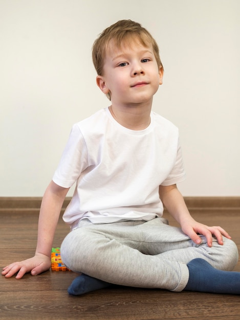 屋内の床に座っている子供