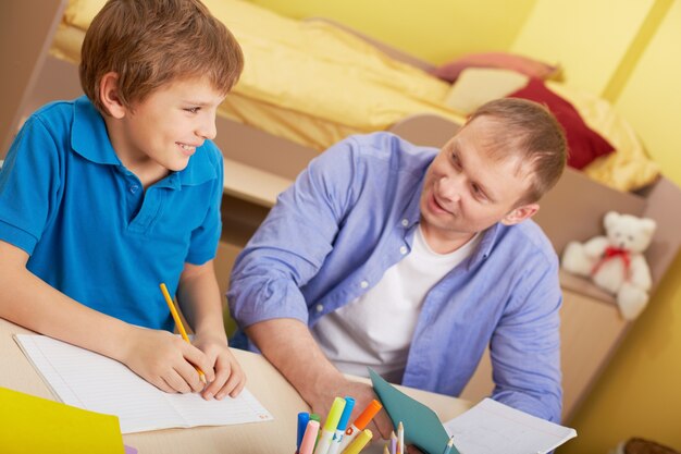 Kid studying with his father