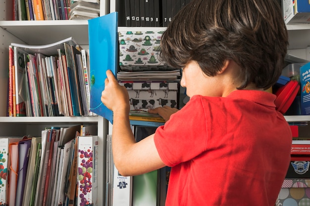 Kid taking book from shelf
