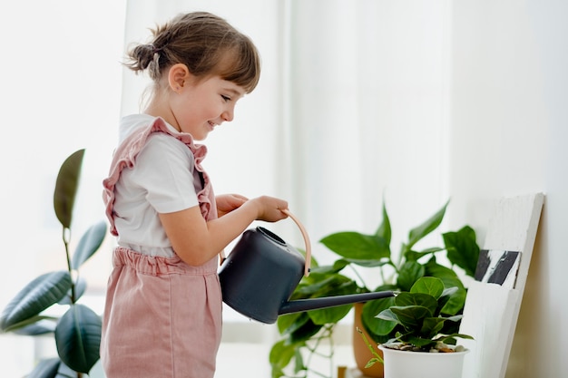 自宅で植物に水をまく子供の