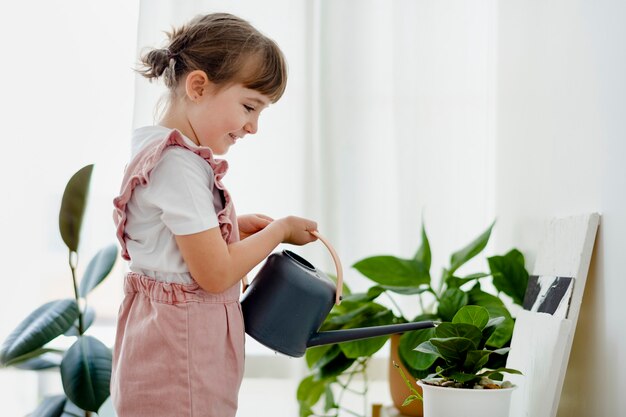 집에서 식물에 물을주는 아이