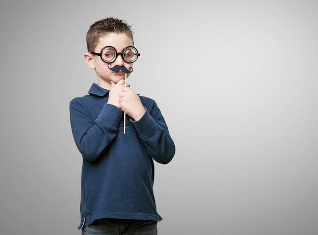 Kid with glasses and fake moustache