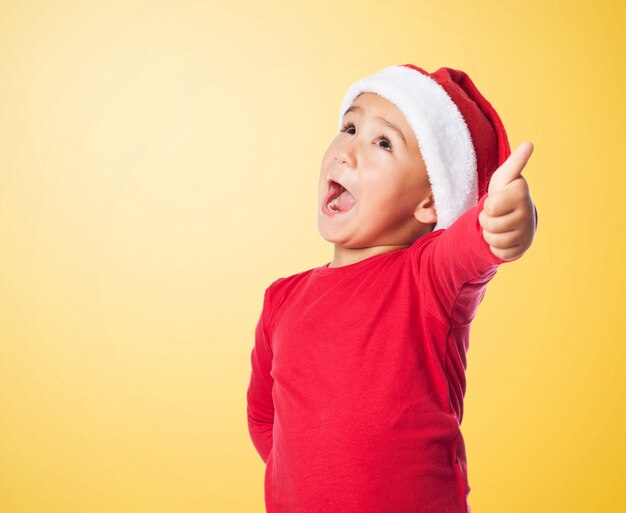 Kid with santa's hat and thumb up