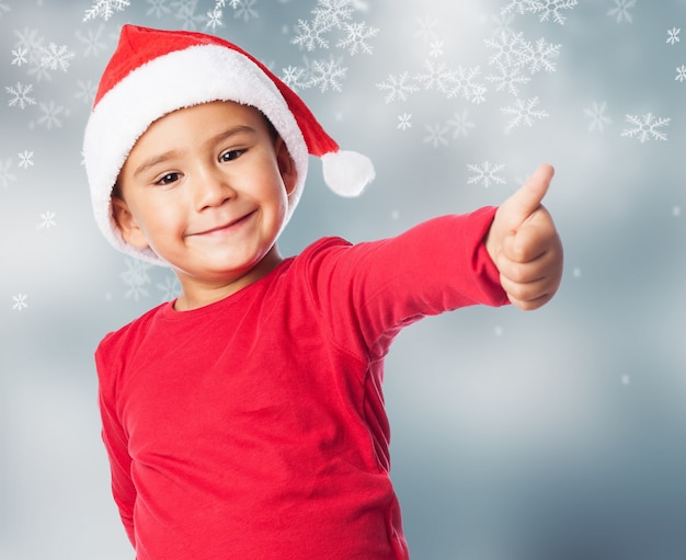 Kid with thumb up and snow background