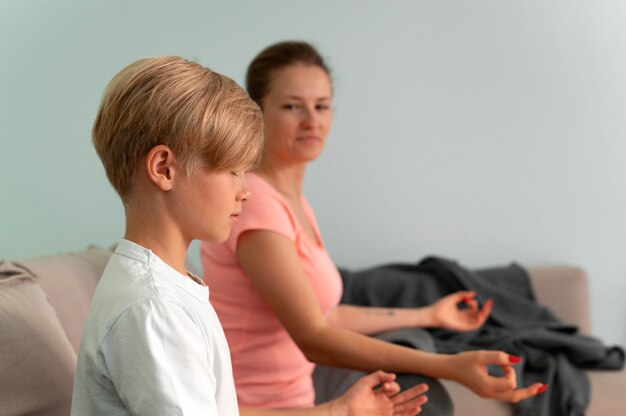 Kid and woman meditating medium shot