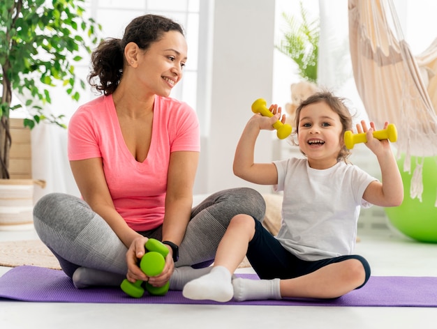 Kid and woman training with dumbbells