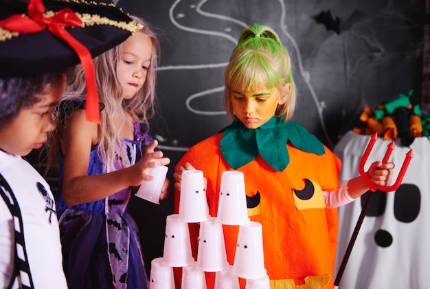 Kids arranging pyramid of plastic cup