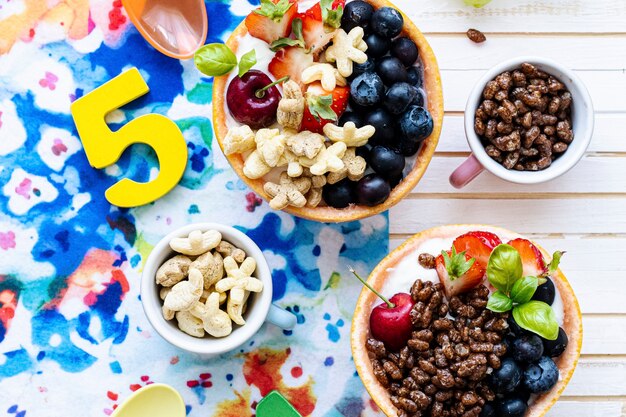 Kids birthday breakfast bowls with cereal and berries