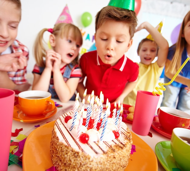 Kids blowing candles on birthday party