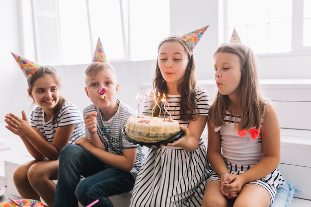 I bambini che spengono le candeline di compleanno e si divertono