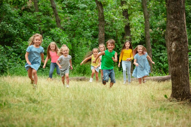 Kids, children running on green meadow