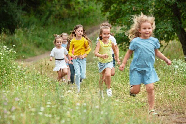 Kids, children running on green meadow