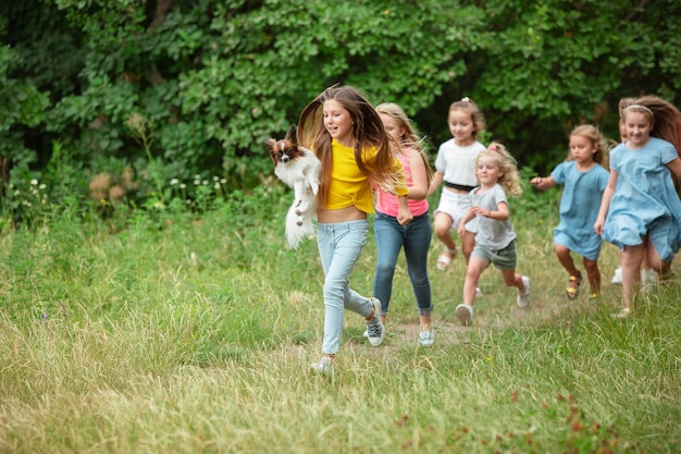 緑の牧草地で走っている子供たち
