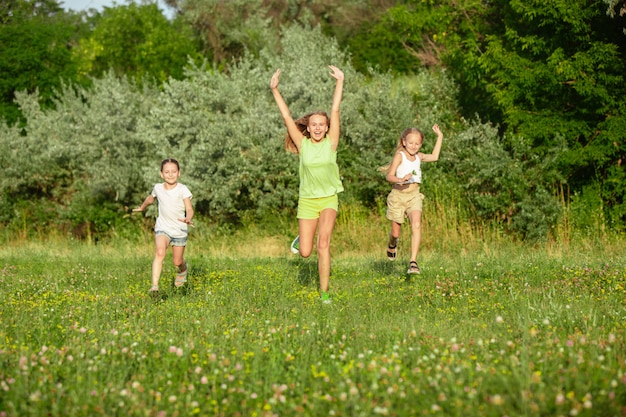 子供たちは、夏の日差しの草原で走っている子供たち。