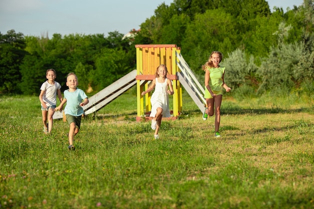 子供たち、牧草地で走っている子供たち