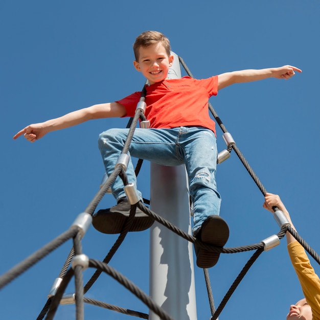 Foto gratuita i bambini si arrampicano insieme sulla corda da vicino