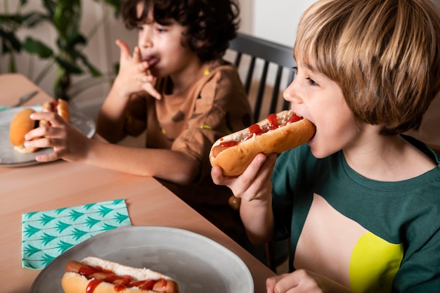 ホットドッグを一緒に食べる子供たち