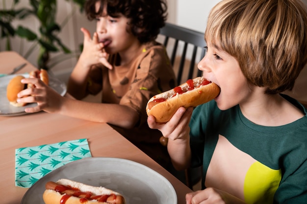 Kids eating hot dogs together