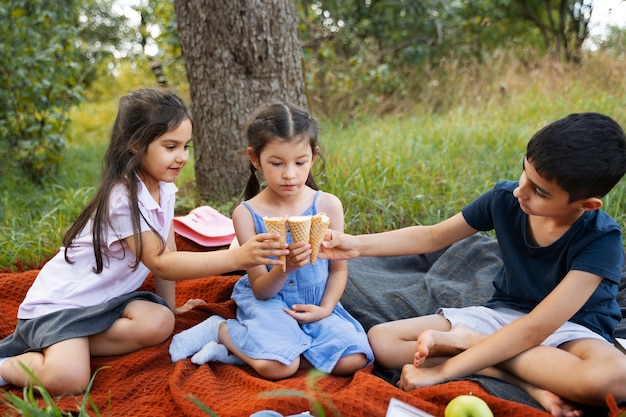 무료 사진 야외에서 함께 아이스크림을 먹는 아이들