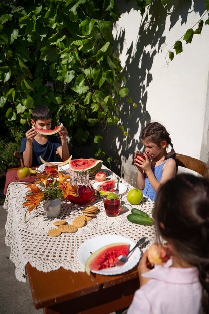 야외 테이블에서 함께 식사하는 아이들