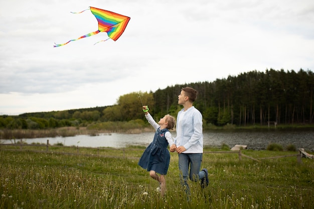 凧のフルショットを飛んでいる子供たち