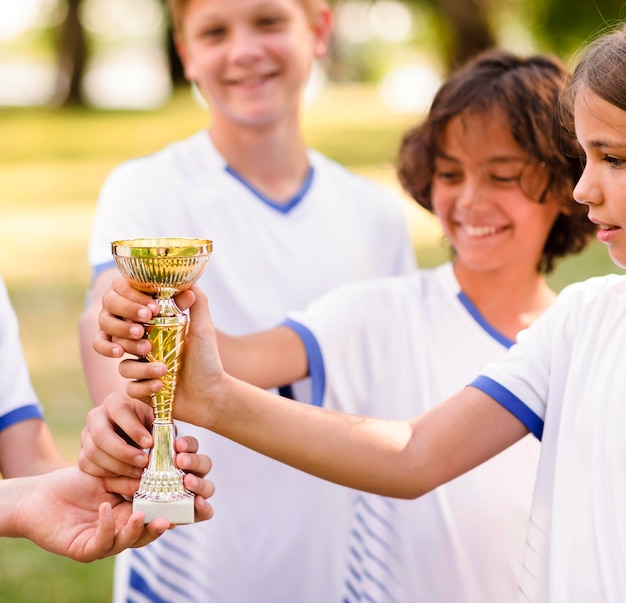 Kids holding a golden trophy