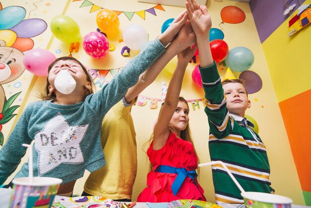 Kids holding hands together on birthday party