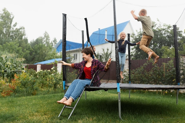 Kids jumping on trampoline full shot