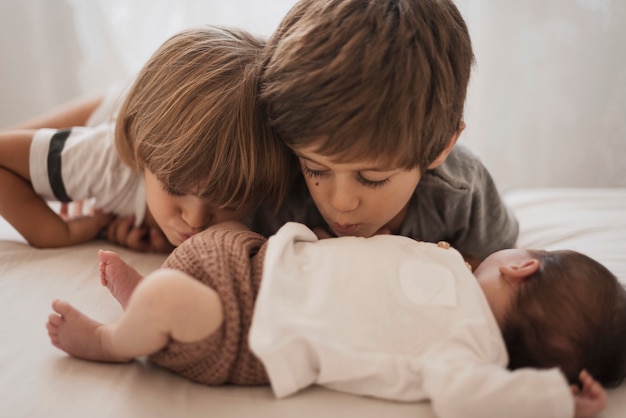 Kids kissing their little brother