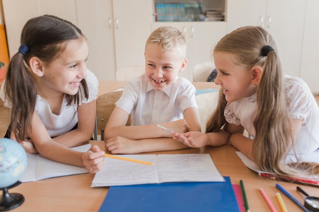 Free photo kids laughing while studying